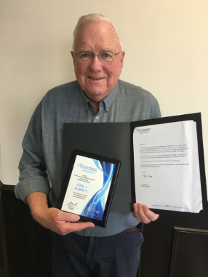 Carl Porrit smiling and holding his over 60 years of TRREB membership award in 2022.
