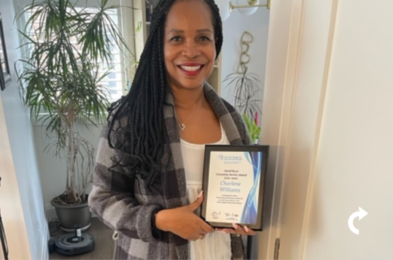 Charlene Williams smiling and holding her 2022 David Rossi Committee Service Award